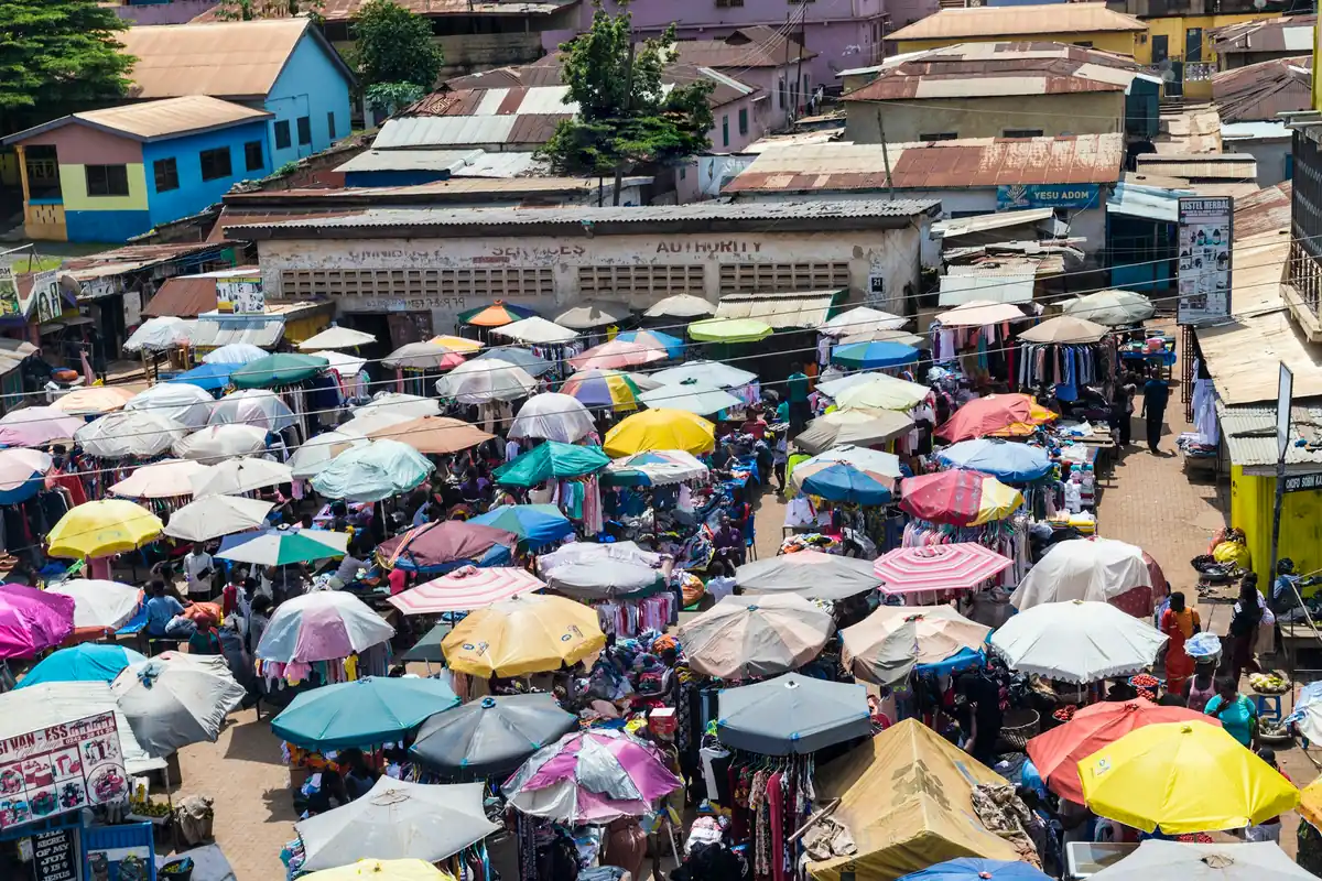 Traders and shoppers under close-packed parasols in a Ghanaian market